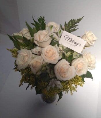 white roses in large glass vase