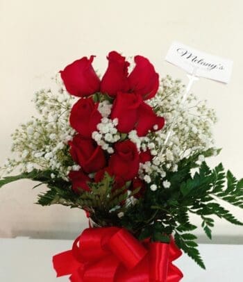 Glass vase with beautiful red roses and baby breath